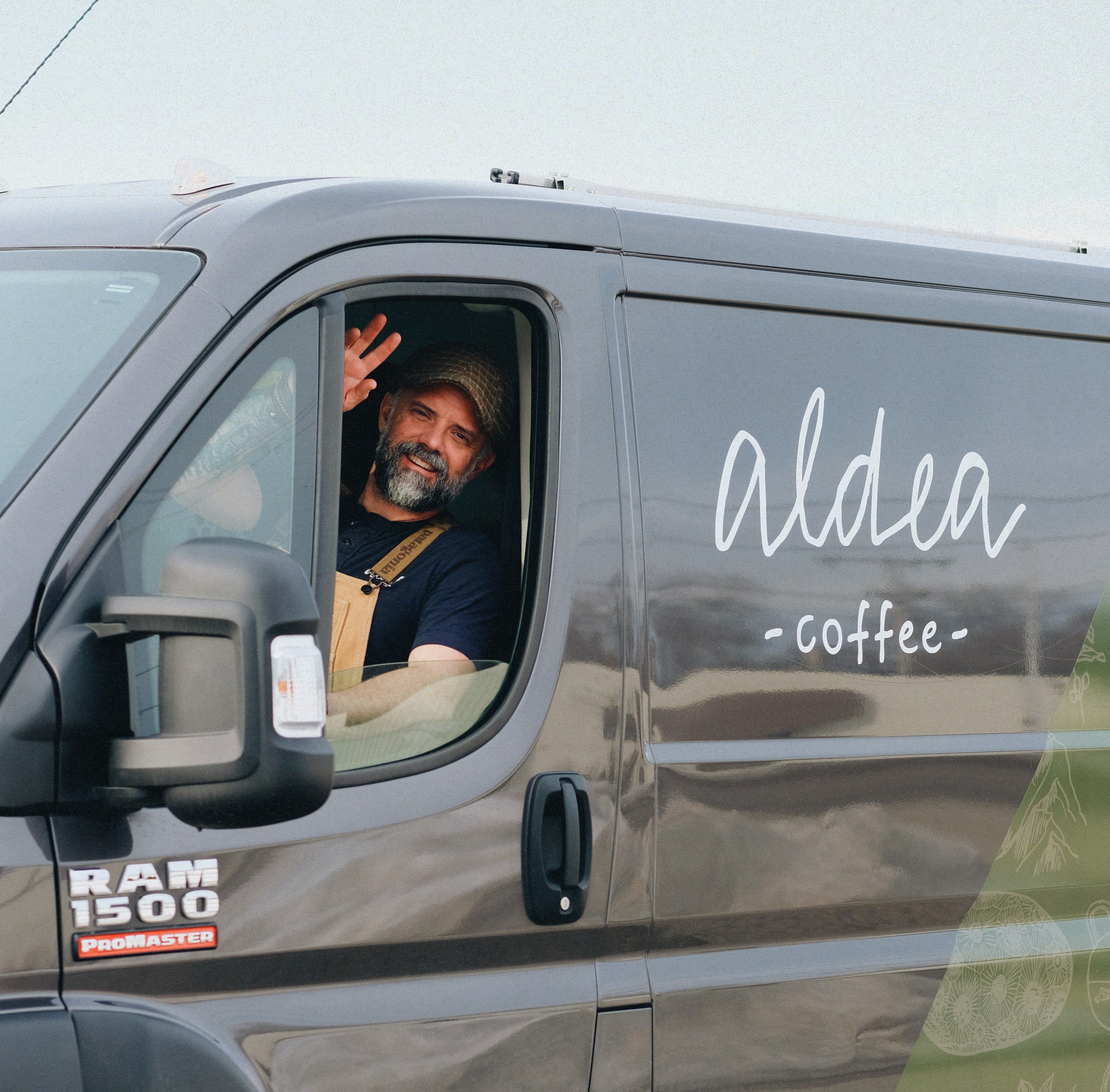 Man waves inside a Ram 1500 Promaster van with Aldea Coffee decal